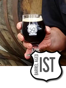 Hand with glass of Barrel Aged Imperial Stout.